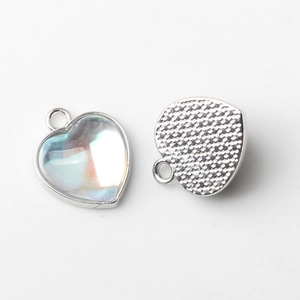 Macro view of heart-shaped alloy pendant with iridescent stone and silver-plated base