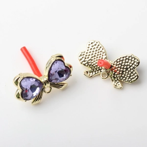 Detail of alloy bow earring findings with purple heart crystals showing front and back