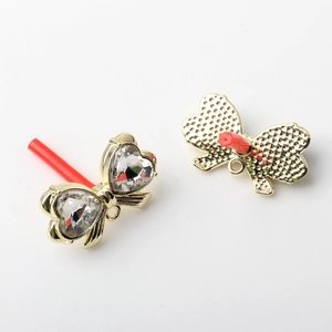 Detail of golden bow earring findings with heart-shaped crystals and hanging ring loops