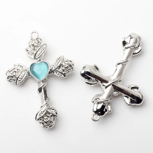 Detail of cross charms with roses and blue heart center for DIY jewelry making