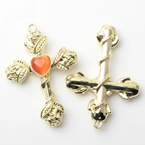 Detail view of gold alloy cross pendant with rose accents and orange heart stone for DIY