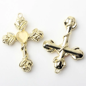 Detailed close-up of gold alloy cross pendant with rose engraving and yellow heart stone
