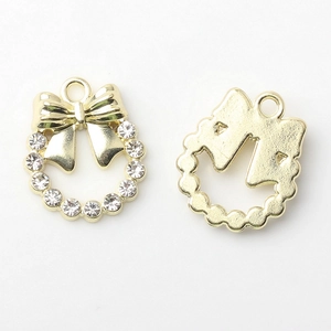 Détail de breloques nœud doré avec strass et perles pour la création de bijoux DIY
