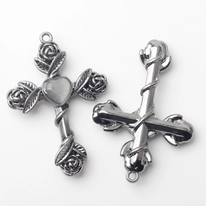 Detailed macro of vintage silver cross charms with rose motifs and cat-eye heart stones