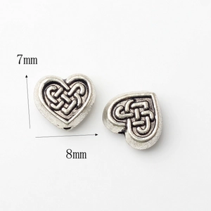Detalle de cuentas de corazón de 7x8mm en plata vieja con grabados de nudos celtas