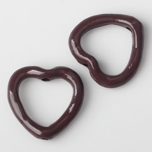 Detail von dunkelbraunen hohlen Herzperlen für DIY-Schmuck und Halsketten basteln