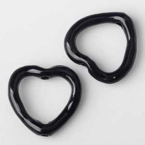 Makro-Detail glänzender schwarzer herzförmiger Legierungsperlen für DIY-Schmuck