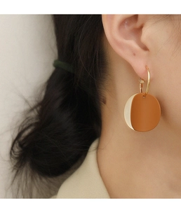 Détail des boucles d'oreilles rondes rétro bicolores Morandi portées par un mannequin