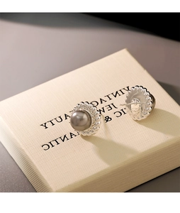 Nahaufnahme der Vintage-Silberohrstecker mit grauen Perlen auf einer Schmuckschatulle