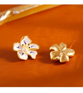 Detail of blue and white enamel flower earrings with pearls and gold-plated studs