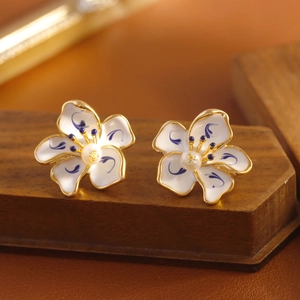 Blue and white porcelain flower earrings with pearl center on dark walnut wood