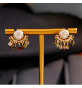 Detalle de pendientes de flecos en plata 925 con perlas y borlas de cuentas de colores