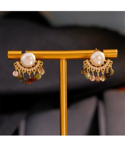 Detalle de pendientes de jade con perlas y borlas de cuentas de colores en soporte dorado