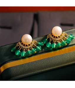 Detalle de pendientes de borla de calcedonia verde con perlas y marco de abanico dorado