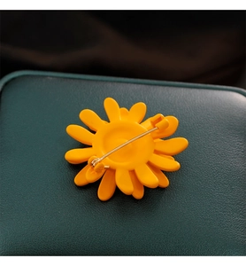 Vue macro du dos de la broche tournesol jaune avec son épingle en métal doré