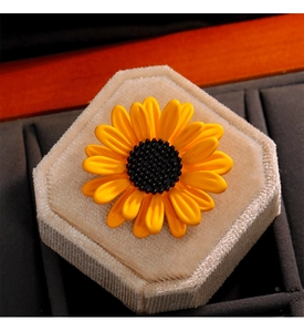 Vue détaillée de la broche tournesol jaune avec finition émail sur un support velours