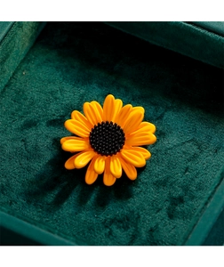 Vue macro de la broche tournesol 3D avec pétales jaunes sur écrin en velours