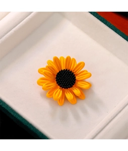 Détails d'une broche tournesol aux pétales jaunes dans son coffret cadeau blanc