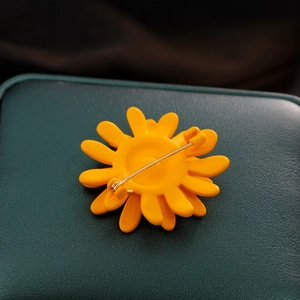 Vue arrière de la broche tournesol jaune avec fermoir métallique sur cuir vert