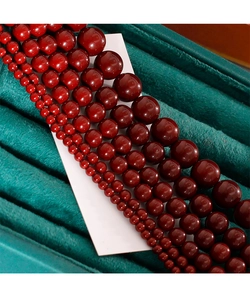 Vue macro de perles rouge foncé brillantes de tailles variées sur un support en velours