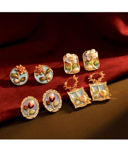 Détails de boucles d'oreilles émaillées vintage avec motifs floraux et perles douces
