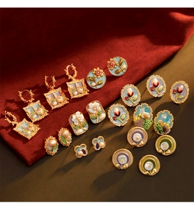 Détails macro de boucles d'oreilles en émail vintage avec perles et motifs floraux peints