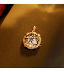 Macro detail of a vintage coin pendant with silver relief head and gold zircon border