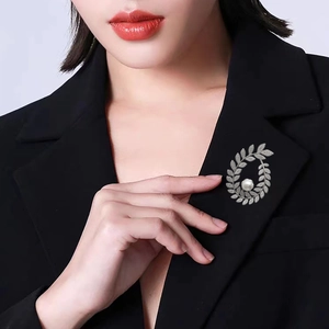 Elegant silver leaf wreath brooch with shimmering crystals and a large white pearl