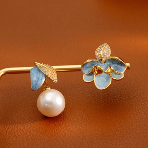 Boucles d'oreilles asymétriques fleur et feuille en émail bleu avec perles et or