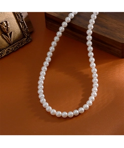 Détails d'un collier de perles blanches avec fermoir magnétique sur fond en cuir vintage