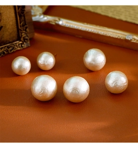 Vue macro de grosses perles de coton ivoire texturées sur un fond en cuir de style rétro