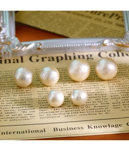 Vue détaillée de six grandes perles blanches au lustre chaud sur fond de vieux journal