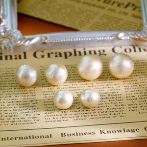 Boucles d'oreilles perles vintage sur journal avec une finition dorée luxueuse