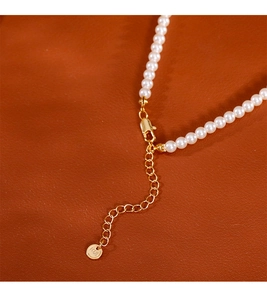Détails du fermoir mousqueton doré et de la chaîne d'extension pour un collier de perles fines
