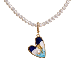 Collier en perles avec pendentif cœur en émail, rose dorée et détails sertis de diamants
