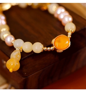 Gros plan d'un bracelet chinois rétro avec pierre d'ambre et pendentif gourde en jade