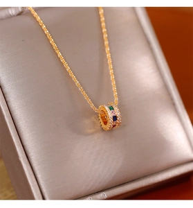 Detailopname van een vergulde ketting met kleurrijke edelstenen op een zijden juwelendoos