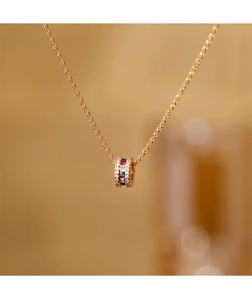 Macro-opname van een gouden cilinder hanger met gekleurde edelstenen en fijne ketting