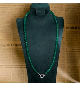 Détail d'un collier en perles de calcédoine verte avec fermoir argenté serti de diamants