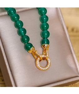 Détail de perles de calcédoine verte avec fermoir doré serti de zircons fins