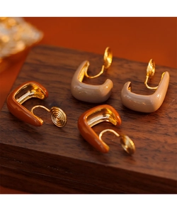 Detailed macro of enamel U-shape clip-on earrings in caramel and beige colors