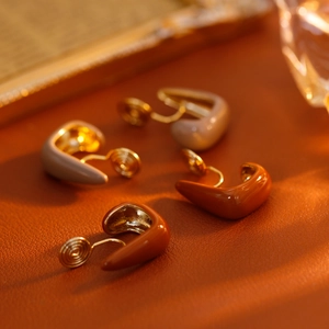 U-shaped Morandi enamel ear clips for non-pierced ears on a brown leather surface