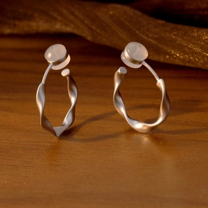Clips d'oreilles torsadés en argent mat avec incrustation de pierre blanche sur bois