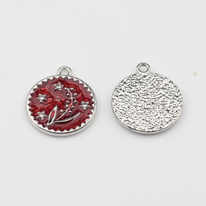 Detail view of round red enamel flower pendant with rhinestones and hammered metal back