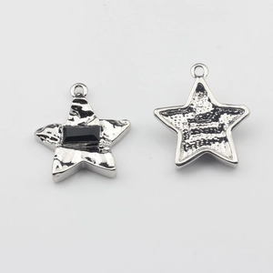 Detalle del colgante de estrella con piedra negra y textura de lava plateada