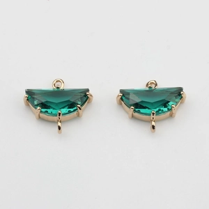 Macro shot of emerald green crystal fan charms with gold plated settings for DIY jewelry