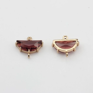 Detail of red crystal fan-shaped charms with gold-plated connectors for DIY jewelry