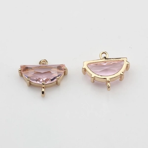 Close-up of pink crystal semi-circle connectors in gold plated settings for DIY jewelry