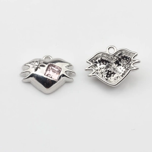 Detailed close-up view of a silver irregular heart pendant with pink gemstone and hollow back