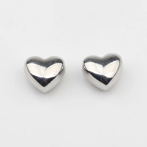 Macro detail of 3D solid heart stud earrings in polished silver finish for DIY jewelry